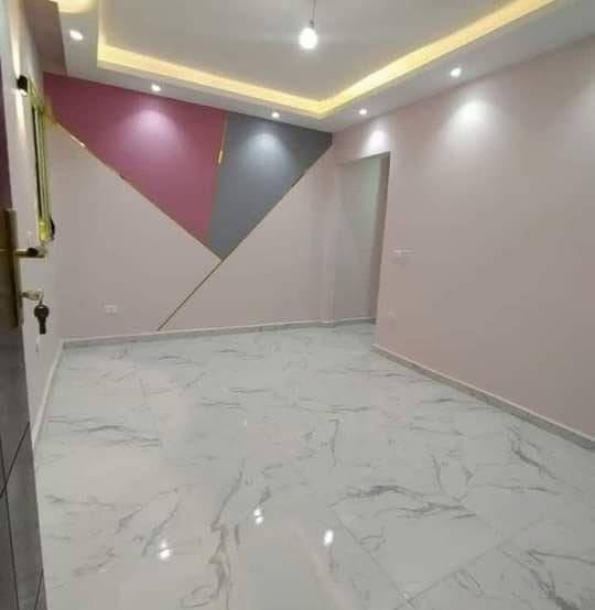 غرفة بجدارية هندسية بالوردي والرمادي